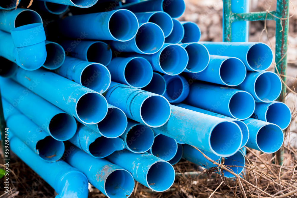 Selective to blue plastic pipe background. PVC pipes stacked in ...