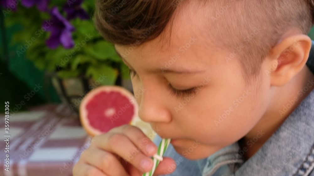 Child drinks fresh homemade lemonade outdoor. Child drinks fresh homemade lemonade outdoor.