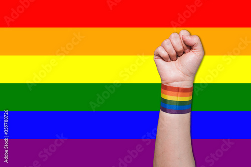 Rainbow flag bracelet arm of gay pride. Fist up with the gay pride flag. Pride. Rainbow bracelet. Gay pride bracelet