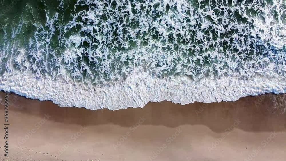 Wellen an der Nordsee rollen an den Strand heran, gesehen aus der Vogelperspektive