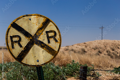 Photo Battered old railroad crossing sign on a country road on the prairie