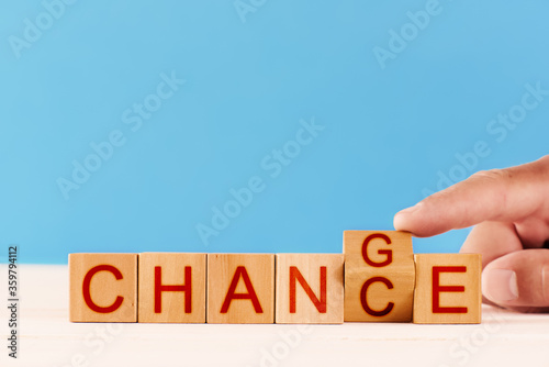 concept chance to change. male hand flips over a wooden block and changes the inscription from the word chance to words change