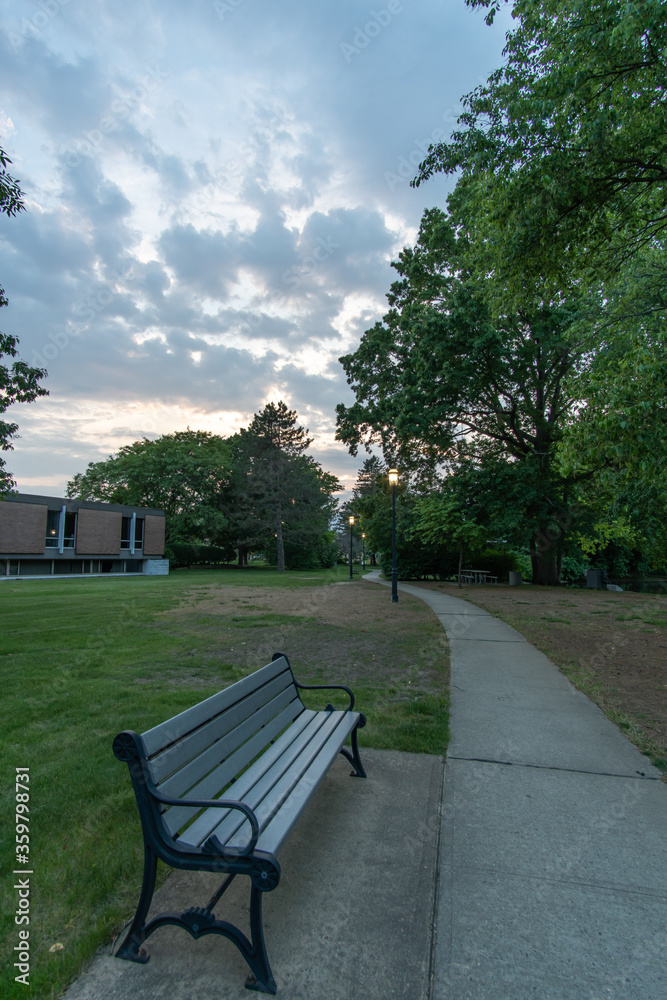 East Brunswick, New Jersey - May 25, 2019: An empty bench sides adjacent to the sidewalk so that people can rest their feet should they get tired walking on the path. 