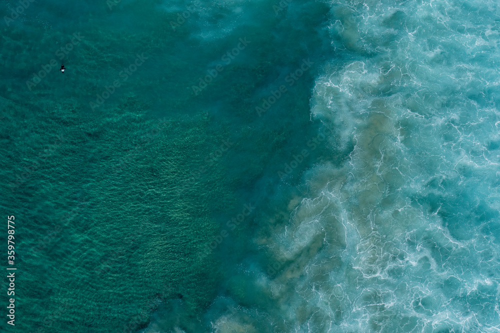 aerial view of ocean waves breaking out at sea.
