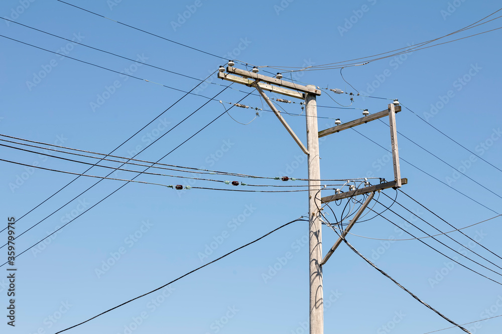 Utility Pole with Many Lines against a Blue Sky Utility Pole with Many Lines against a Blue Sky