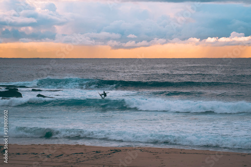 Silhoette of surfer at sunrise over Maroubra beach in Sydney Australia
