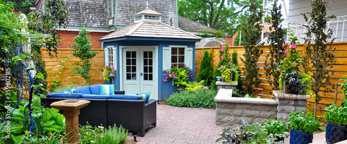 Εκτύπωση καμβά Banner of beautiful professionally designed hardscaping in a luxury garden oasis featuring a patio, plantings, seat wall outdoor furniture and shed