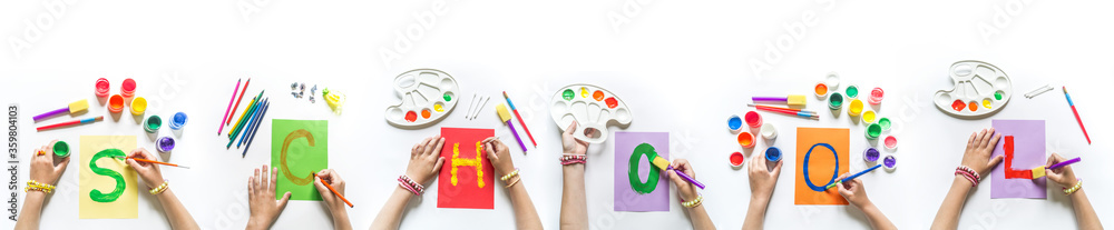 Obraz premium Children's hands write the word School