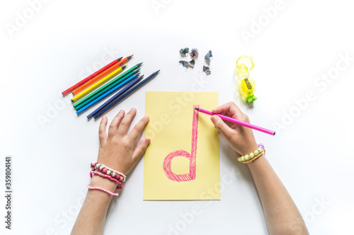 Children hands write the letter D colored pencils photo