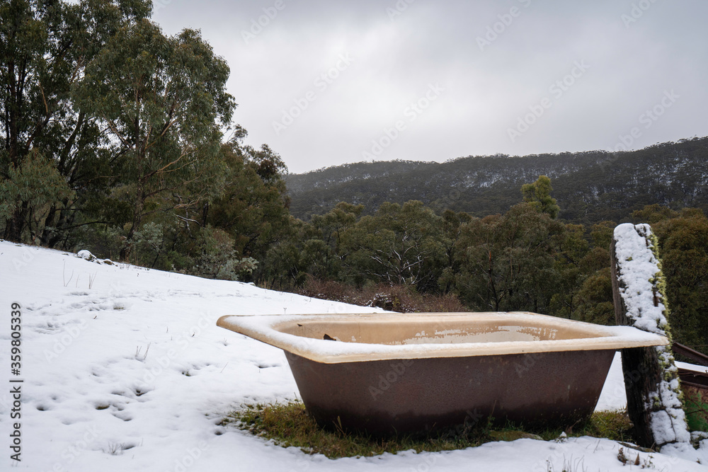 old bath water trough for animals on farm covered in snow in winter
old bath water trough for animals on farm covered in snow in winter