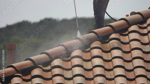 Pressure-washing a roof, medium close up of high power spray