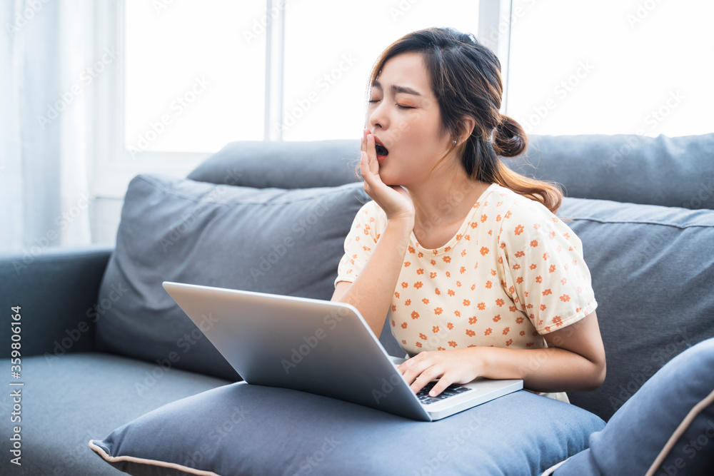Asian businesswoman work at home using computer laptop technology freelance business plan strategy tired sleepy yawning working from home living room modern office during coronavirus COVID-19 pandemic Asian businesswoman work at home using computer laptop technology freelance business plan strategy tired sleepy yawning working from home living room modern office during coronavirus COVID-19 pandemic