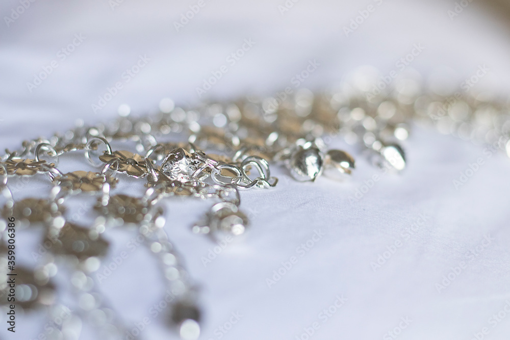 silver jewelry charms on a white fabric silver jewelry charms on a white fabric