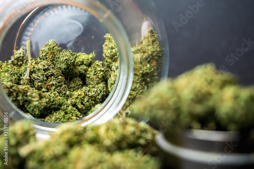 фотографія Medical Marijuana flower buds in glass jar and grinder