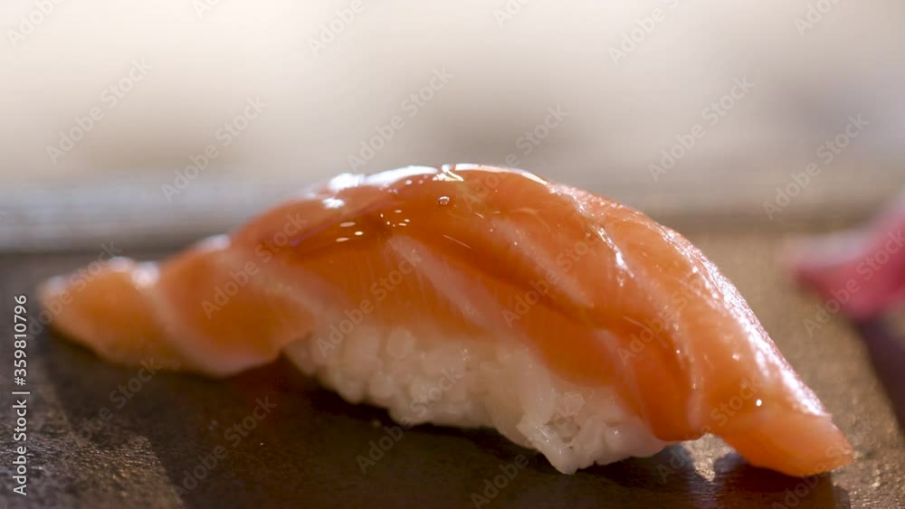 Tasty macro of a nigiri with fresh raw salmon and rice sushi, brushed with soy sauce and burned with flame. Traditional Japanese smoked fish food. Tasty macro of a nigiri with fresh raw salmon and rice sushi, brushed with soy sauce and burned with flame. Traditional Japanese smoked fish food.