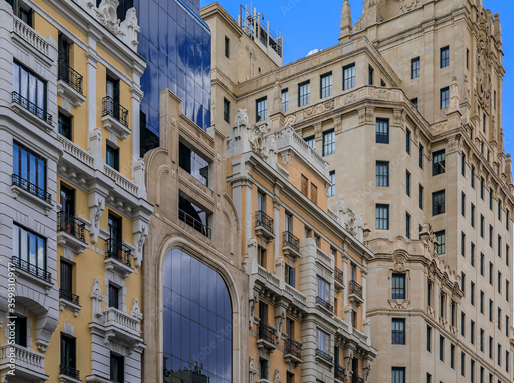 Facades of beautiful buildings on Gran Via shopping streets in the center of the city in Madrid, Spain
