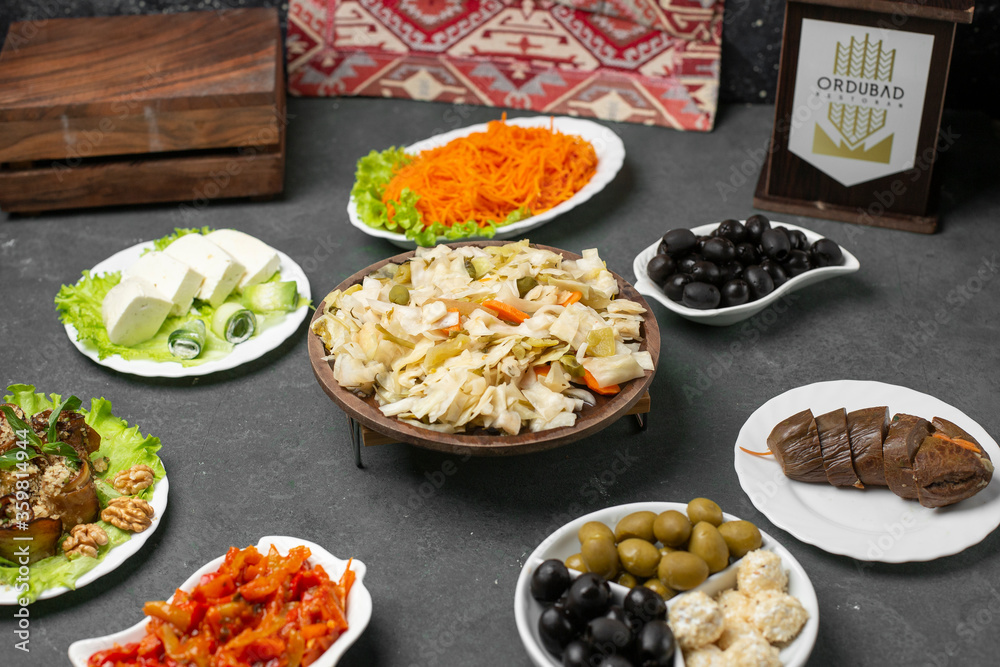 Marinated cabbage salad served with cheese and olives on blue table Marinated cabbage salad served with cheese and olives on blue table