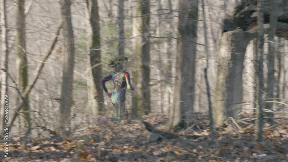 Woman in colorful skull suit runs through the woods Woman in colorful skull suit runs through the woods