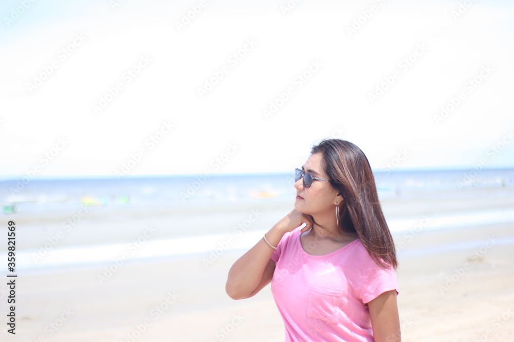 Asian women wearing pink shirts are stand with joy and freshness. On active, air, beach, beautiful, beauty, bikini, blue, body, carefree, concept, enjoy on summer holiday, Summer concept. Happy summer Asian women wearing pink shirts are stand with joy and freshness. On active, air, beach, beautiful, beauty, bikini, blue, body, carefree, concept, enjoy on summer holiday, Summer concept. Happy summer