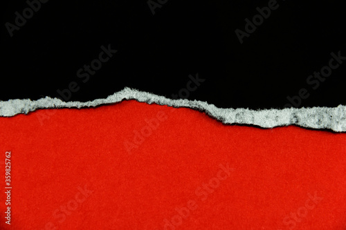 Black torn paper on a red background that is for copying advertisements or text, images and designs. © Alek