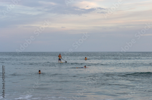 pessoas praticando stand up paddle na praia