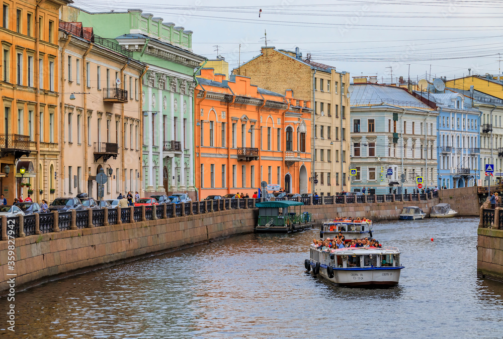 Obraz premium Waterfront buildings on the banks of river Neva and tourist boats on the water in Saint Petersburg