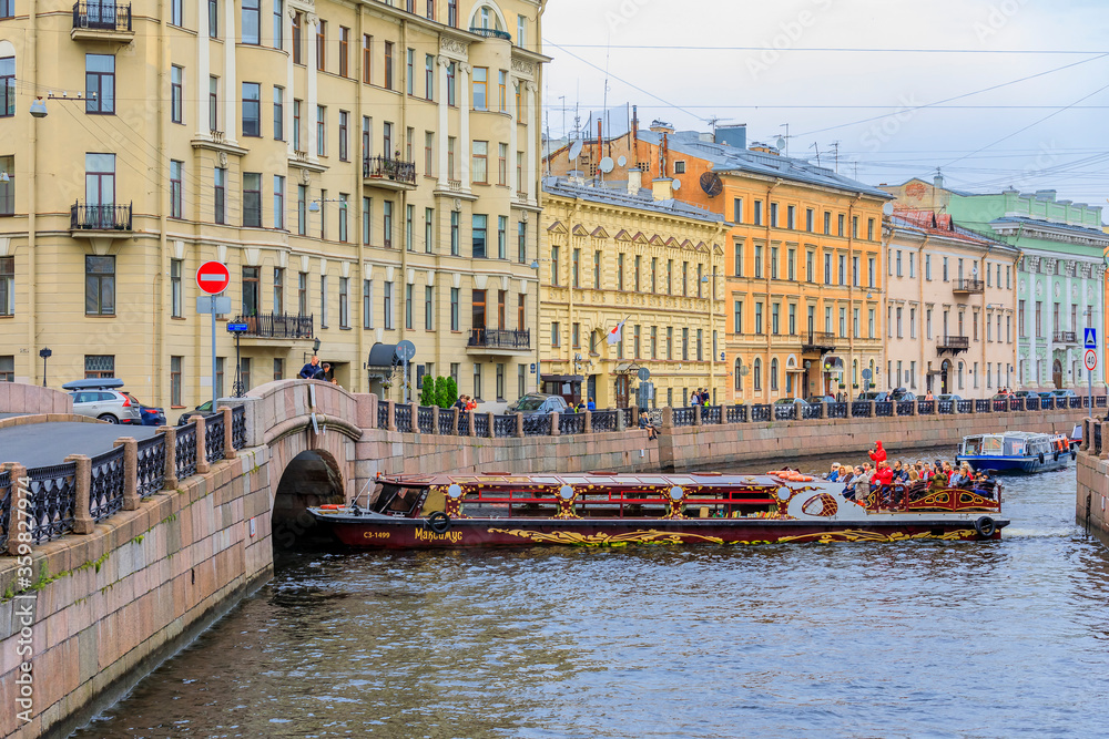 Obraz premium Waterfront buildings on the banks of river Neva and tourist boats on the water in Saint Petersburg