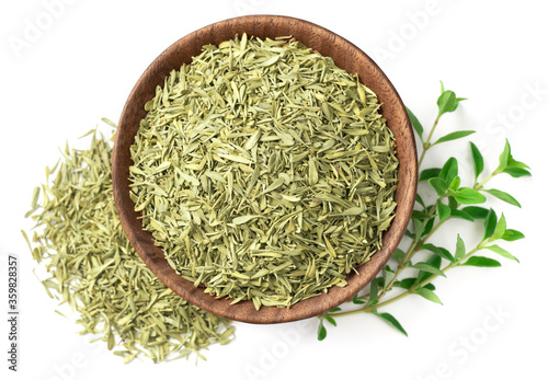 dried thyme leaves in the wooden bowl, with fresh thyme isolated on white background, top view