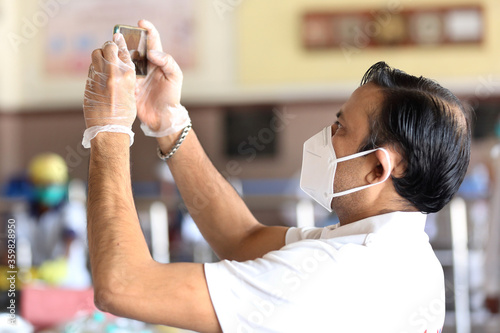 A young man at work during Covid-19 pandemic. young man in mask and gloves shooting during lock down in India wearing N95 mask. 