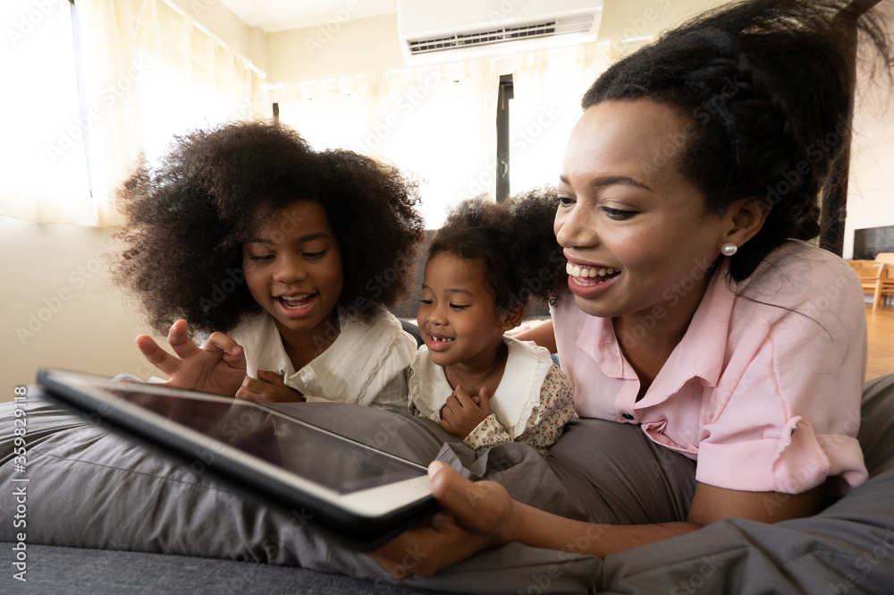 Happy American African family watching tablet on bed at home, The concept of families of all ages is enjoying the activities in the house. - obrazy, fototapety, plakaty 