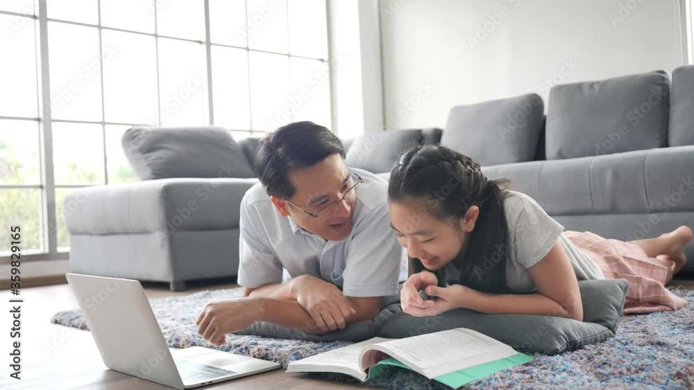 Asian Father teaches daughter books by using laptop computer Study online Asian Father teaches daughter books by using laptop computer Study online