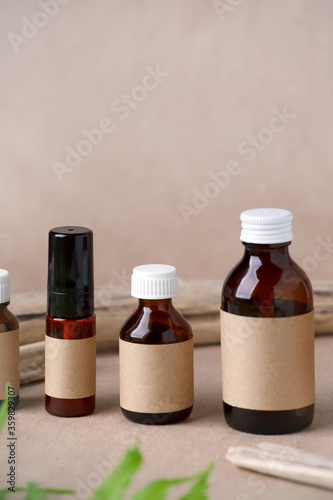 Set of cosmetic dark amber glass bottles with paper craft label for mock up. Closeup, copyspace. Beauty blogging, salon treatment concept, minimalism brand packaging