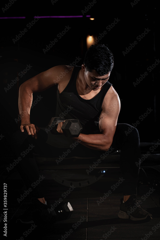 Handsome man raising dumbbell,doing exercise for buit muscle,fit and firm body,model posing Handsome man raising dumbbell,doing exercise for buit muscle,fit and firm body,model posing