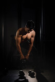 Handsome man raising dumbbell,doing exercise for buit muscle,fit and firm body,model posing