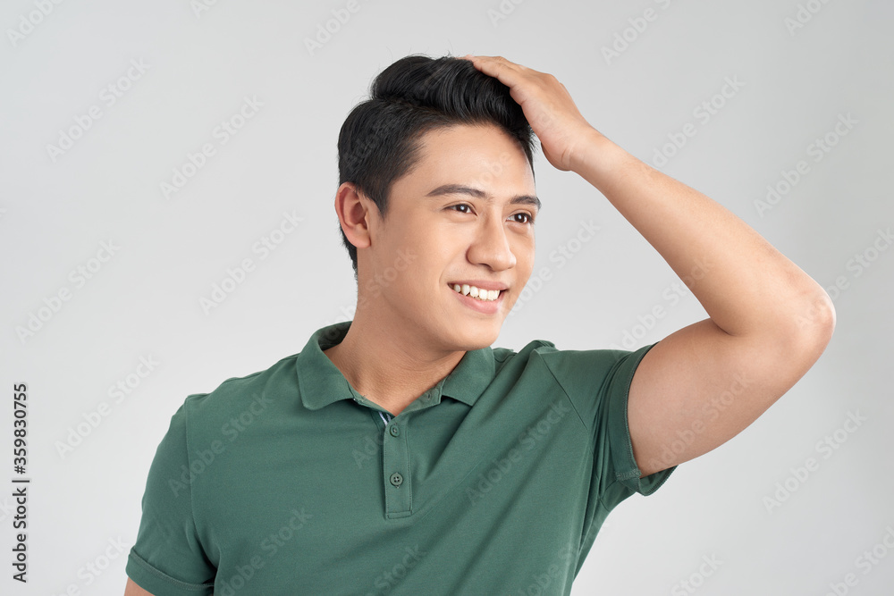 Young handsome man wearing green t-shirt over isolated background Smiling confident touching hair with hand up gesture, posing attractive Young handsome man wearing green t-shirt over isolated background Smiling confident touching hair with hand up gesture, posing attractive