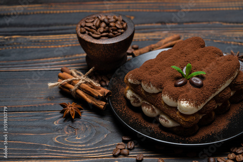 Classic tiramisu dessert on ceramic plate on wooden background