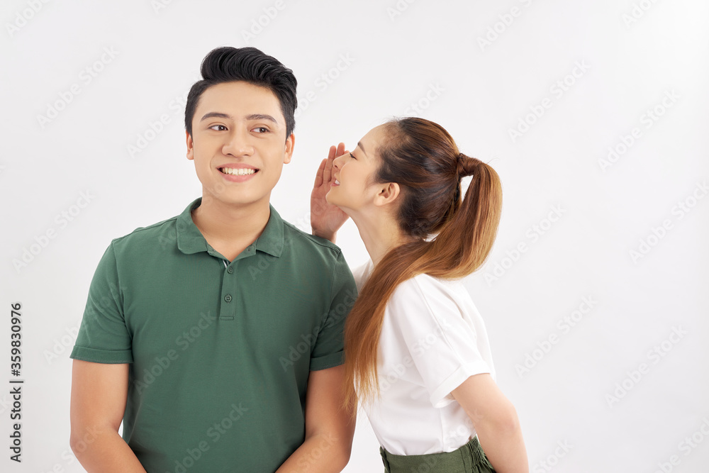 young girl whispering to her boyfriend over white background young girl whispering to her boyfriend over white background