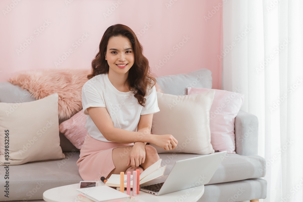 Young Asian casual woman working small business online sitting and looking at camera and smiling at home office. Freelance Startup Small business owner, Online selling, e-commerce. Young Asian casual woman working small business online sitting and looking at camera and smiling at home office. Freelance Startup Small business owner, Online selling, e-commerce.
