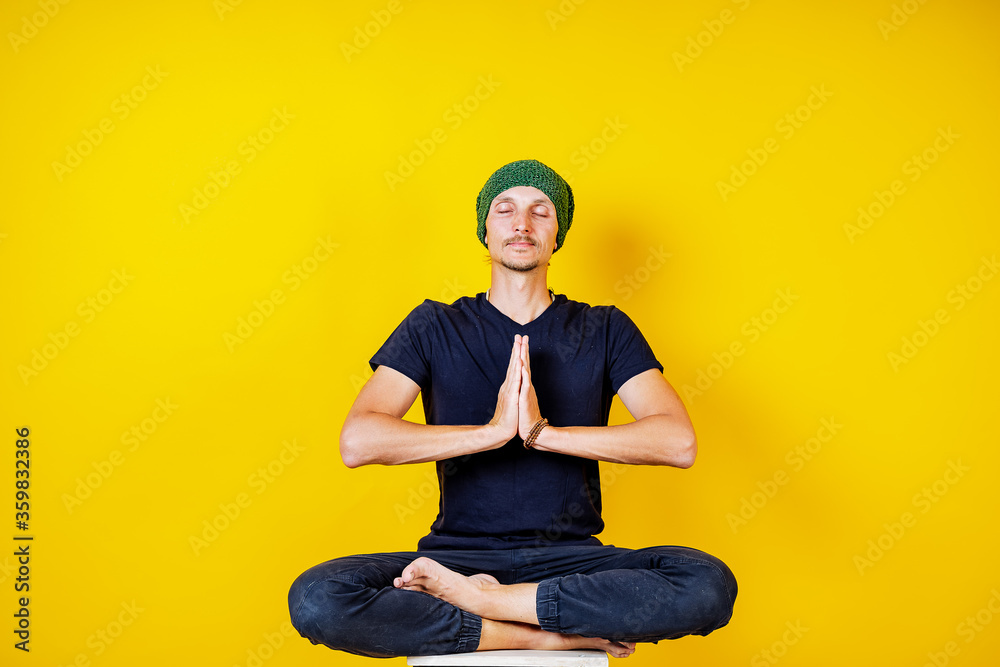 white male hipster doing yoga on a yellow background, yoga exercises and asanas, meditation, calm white male hipster doing yoga on a yellow background, yoga exercises and asanas, meditation, calm
