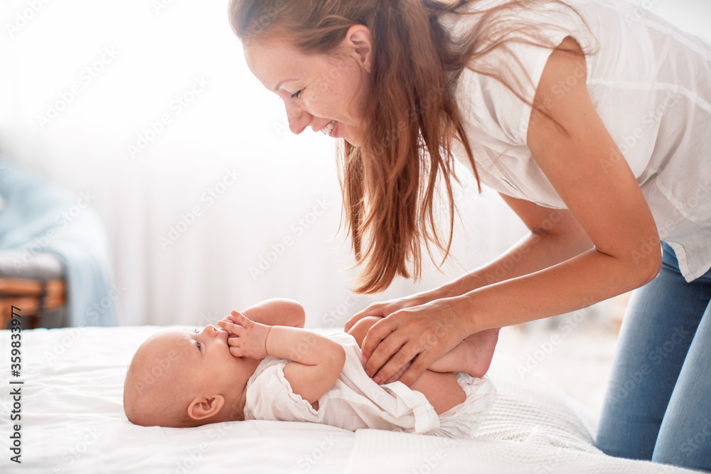 Happy loving family. A young mother plays with her child in the bedroom. Happy loving family. A young mother plays with her child in the bedroom.