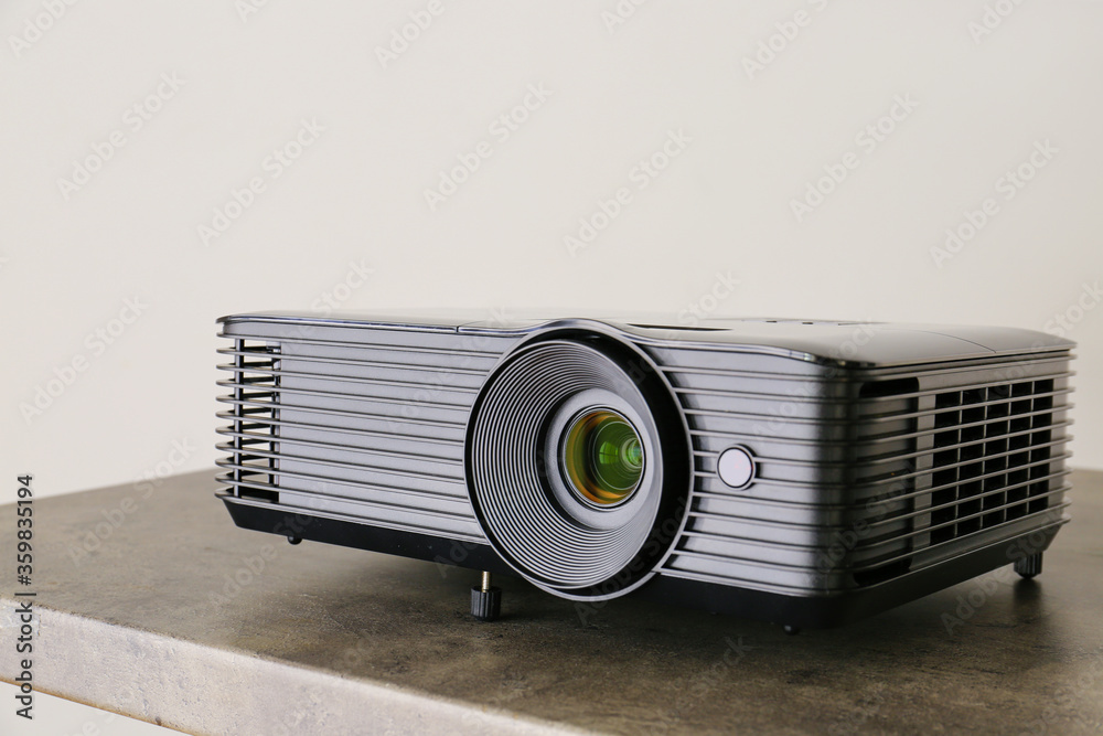 Fototapeta premium Modern video projector on table against grey background