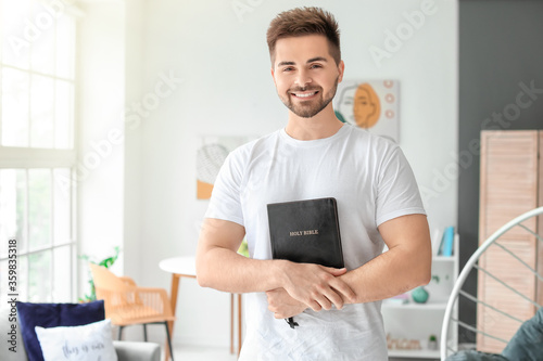 Young man with Bible at home