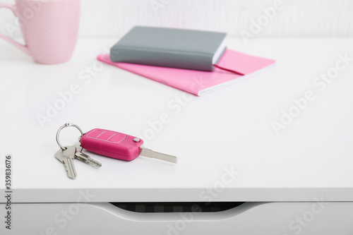 Keys from house and car on table in room photo