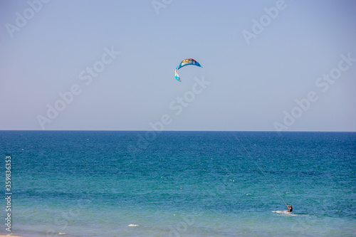 kite surfer on the beach under the blue sky