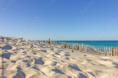 Fence atop sand dunes at beach