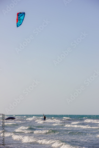 kite surfer on the beach under the blue sky
