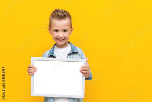 Happy smiling kid holding white frame with copy space for text certificate or diploma