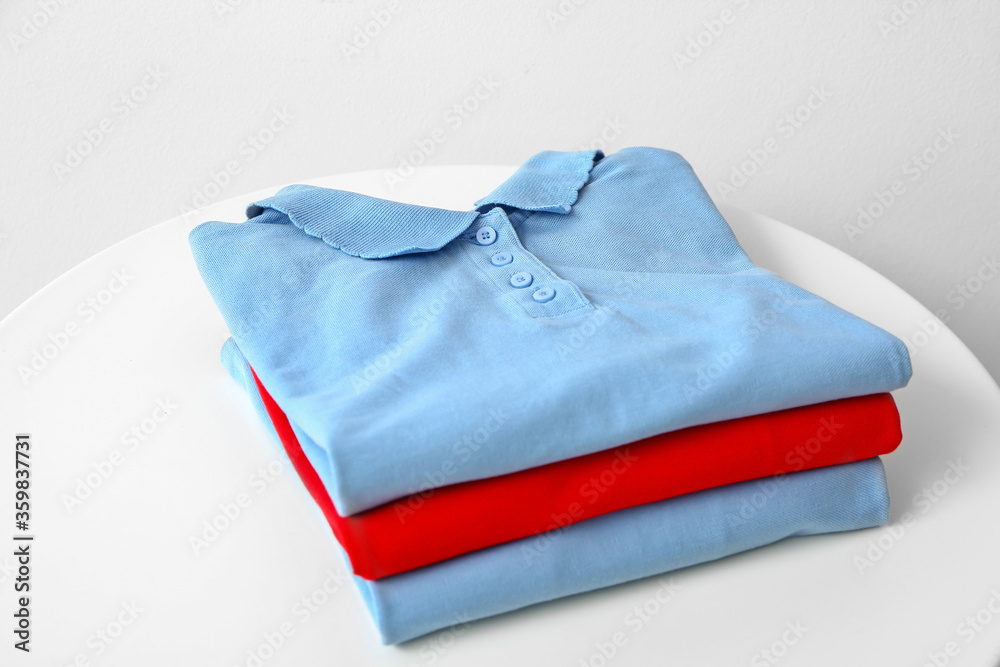 Stylish kid t-shirts on table in room Stylish kid t-shirts on table in room