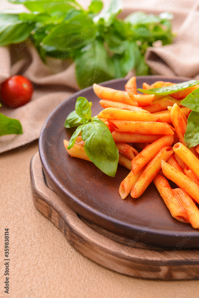 Plate with tasty pasta, basil and tomato sauce on table Plate with tasty pasta, basil and tomato sauce on table