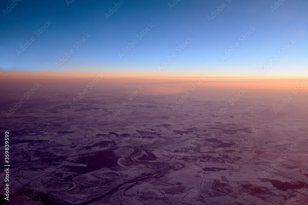 Twilight view on snowy ground from airplane in winter Twilight view on snowy ground from airplane in winter